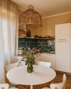 费拉约港Appartamento il Rosmarino的厨房配有白色的桌子和花瓶