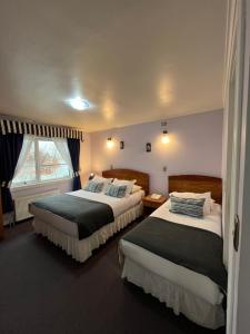 瓦尔迪维亚Montepiedra Costanera Valdivia的酒店客房设有两张床和窗户。