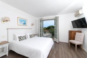 昂蒂布币奥酒店 - 昂蒂布海角的一间白色卧室,配有床和电视