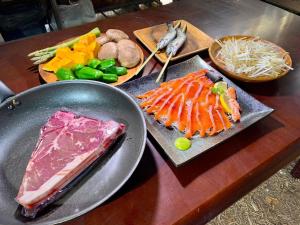 ShimodaMinamiaso STAYHAPPY - Vacation STAY 57906v的餐桌上摆放着不同种类的肉类和蔬菜