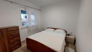 科尔丘拉Apartman AnTe的一间卧室配有一张床、一个梳妆台和一扇窗户。