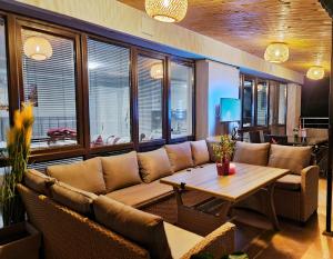 桑丹斯基Парк Апарт-Хотел Виктория 1的客厅配有沙发和桌子
