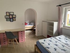 格拉绍Auszeit Haus的一间卧室配有一张床、一张桌子、一张床和一把椅子