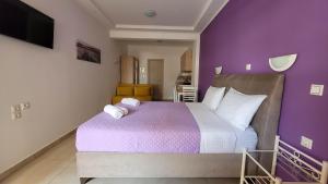 帕尔加Valeriana Studios的一间卧室设有一张紫色墙壁的大床