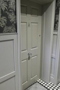 惠特利湾约克之家酒店的一间铺有 ⁇ 板的房间内的白色门