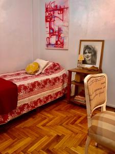 布宜诺斯艾利斯Te invito a Compartir mi Depto. Artlovers. Solo Damas.的卧室配有1张床、1张桌子和1把椅子