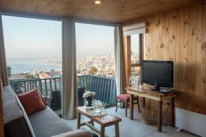 瓦尔帕莱索Hotel Faro Azul Valparaíso Cerro Alegre的客厅配有沙发,阳台上配有电视