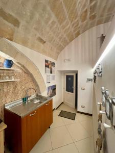 莫诺波利Dimora Aversa的厨房设有水槽和砖墙