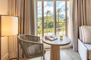德尼亚Denia Marriott La Sella Golf Resort & Spa的客房设有桌子、椅子和窗户。