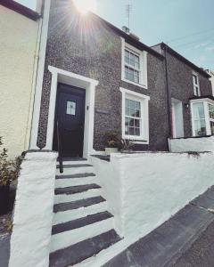 波特马多克Bryn Goleu, Mersey Street, Borth-y-Gest的砖屋,有黑色的门和楼梯
