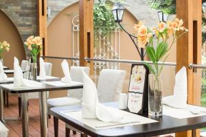 特鲁希略大侯爵酒店的一排桌子上摆放着白色椅子和鲜花