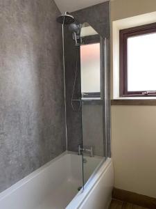 CloughtonWagtail Cottage的浴室里设有玻璃门淋浴