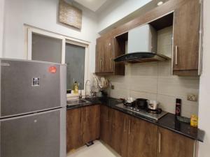 伊斯兰堡Spacious private ,Family 1BR Apt/Netflix/wifi/的厨房配有木制橱柜和不锈钢冰箱。