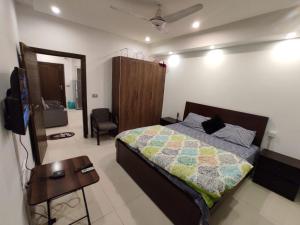 伊斯兰堡Spacious private ,Family 1BR Apt/Netflix/wifi/的一间卧室配有一张床、一张桌子和一台电视