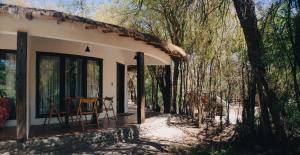 圣佩德罗·德·阿塔卡马Lodge Atacama Horse的树林中的小屋,门廊上配有桌子