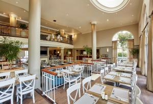 开普敦StayEasy Century City的一间设有白色桌子和白色椅子的餐厅