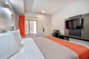 拉斐特美国最佳价值套房酒店 的一间卧室设有一张大床和一台平面电视。