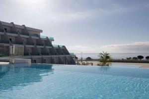 科斯塔特吉塞Radisson Blu Resort, Lanzarote Adults Only的大楼前的大型游泳池