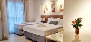 巴西利亚BSB Stay Premium - Flats Particulares - SHN的酒店客房设有两张床和一张桌子。