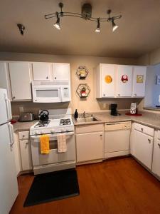 洛杉矶Mario & Harry Potter Loft Universal Studios 10min loft apartment的厨房配有白色橱柜和炉灶烤箱。