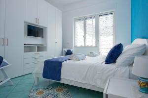 米诺利Casa Sammarco的蓝色和白色的卧室设有床和窗户