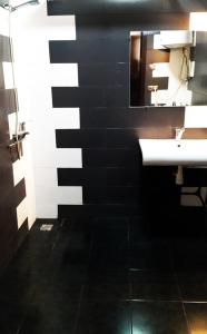 巴统Eka Guest House的黑白浴室设有水槽和镜子
