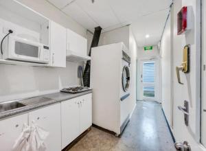 阿德莱德Studio 18 Wright Lodge的白色的厨房配备了微波炉和冰箱。