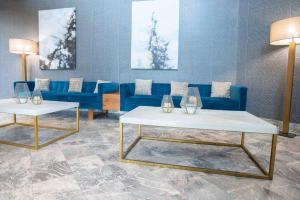 米西索加桑德曼标志米西索加酒店的客厅配有蓝色的沙发和2张桌子