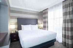 米西索加桑德曼标志米西索加酒店的卧室设有一张白色大床和一扇窗户。