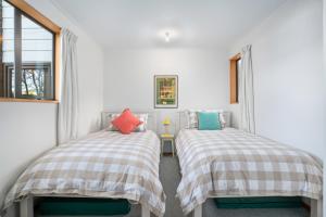 瓦纳卡Wanaka Tranquility - Wanaka Holiday Home的带窗户的客房内设有两张单人床。