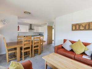 格文Brunston Castle Lodge的客厅以及带红色沙发和桌子的厨房。