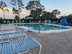布雷登顿Home in Arbor Terrace Resort的一个带蓝色椅子和一束水的游泳池