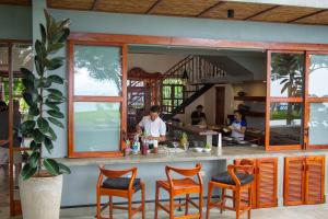 El EdénEl Guayacan Retreat的餐厅设有配备橙色椅子的酒吧