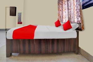 贾姆谢德布尔OYO Flagship Prakash Inn的一张带红色枕头的床