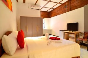 暹粒Daisy Angkor Bungalow的一间卧室配有带白色床单和红色枕头的床。