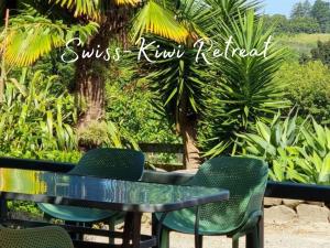 陶朗加Swiss-Kiwi Retreat A self-contained Appartment and a Tiny House option的一张黑桌子和椅子,上面种有树木和植物