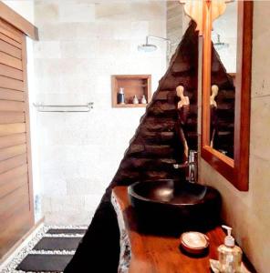 吉利特拉旺安吉利糖小屋旅馆的一间带黑色水槽和楼梯的浴室