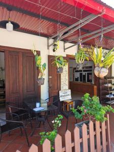 琅勃拉邦Chitlatda Bila House的一间设有桌椅和盆栽的餐厅