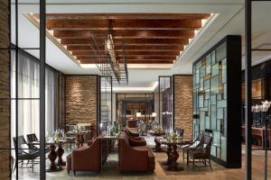 海口海口丽思卡尔顿酒店的餐厅设有桌椅和砖墙