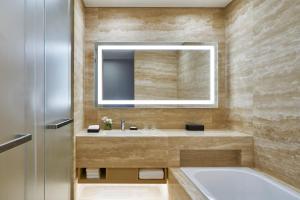 西归浦市万豪济州神话世界酒店的带浴缸、水槽和镜子的浴室