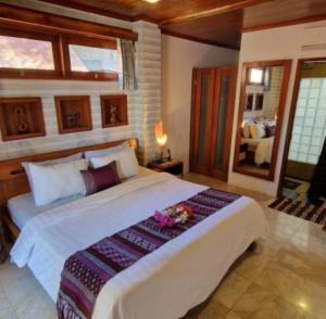 吉利特拉旺安吉利糖小屋旅馆的一间卧室配有一张白色大床,床上有鲜花