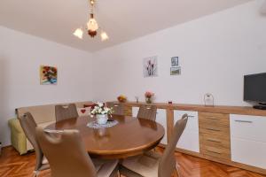木洛希尼Sea View Apartment Sandra in Mali Lošinj的一间带木桌和椅子的用餐室