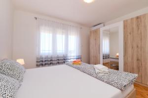 木洛希尼Sea View Apartment Sandra in Mali Lošinj的卧室配有白色的床和窗户。