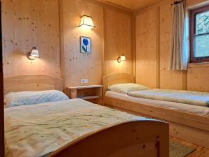 DebantChalet Faschingalm的木墙客房的两张床