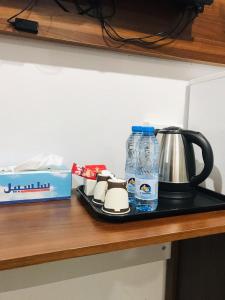 尼兹瓦MY HOTEL Nizwa Residence Hotel Apartement نزوى ريزيدنس的配有咖啡壶和一瓶水的柜台