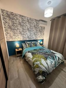 圣丹尼斯La Case Baies Roses - Maison F2的一间卧室配有一张带花卉图案墙壁的床