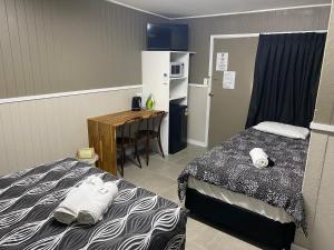 查特斯堡Rix Hotel Motel的带两张床和一张桌子的房间以及一间厨房