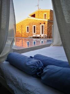 圣弗朗西斯科哈维尔Casa rural isleña的窗户间内的一张带蓝色枕头的床