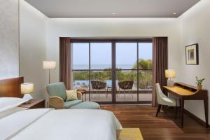 马哈巴利普拉姆Sheraton Grand Chennai Resort & Spa的酒店客房配有一张床、一张书桌和一张书桌。