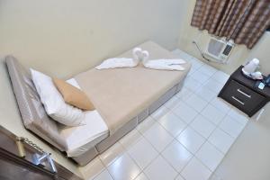 马尼拉马卡提阿麦克斯宾馆的一间设有床铺和毛巾的房间